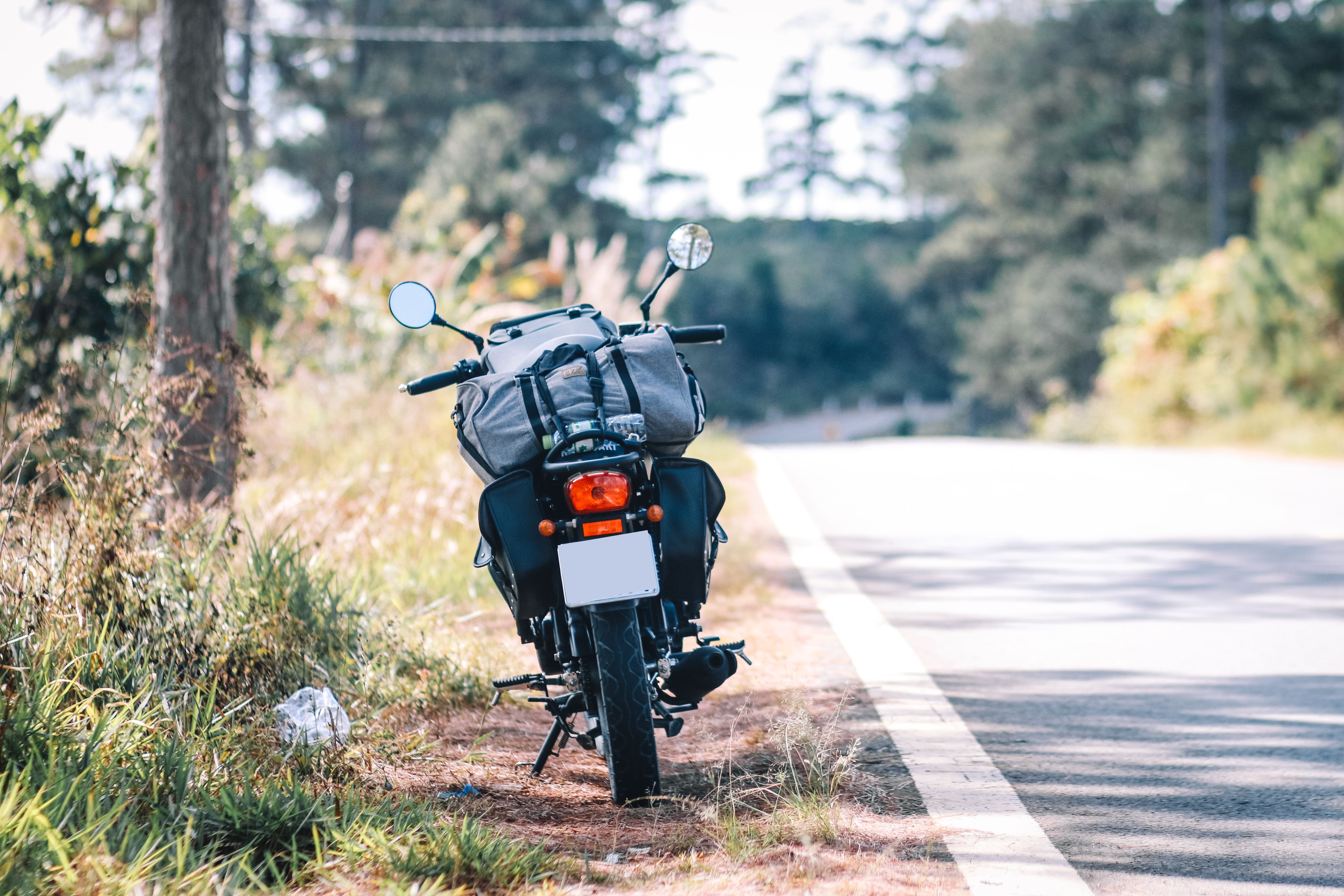 Motorcycle parked beside a scenic rural road, suggesting a long-distance touring route.
